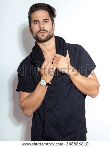 handsome and fit young man in casual outfit posing with wrist watch