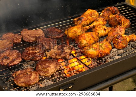 The concept of sunny summer days with Golden drumsticks & sizzling burgers cooking on the Barbecue / Golden drumsticks & sizzling burgers