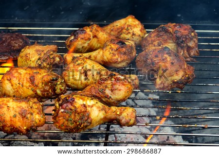 The concept of sunny summer days with Golden drumsticks & sizzling burgers cooking on the Barbecue / Smokey BBQ Chicken drumsticks