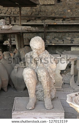 Pompei man with hands covering face before death among antique objects found in excavations