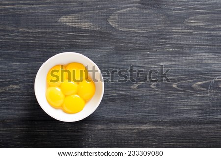 Egg yolks in a bowl on a wooden table