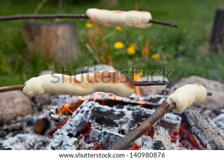 bread on a stick over a fire on long twigs until they are a saft flufy golden brown