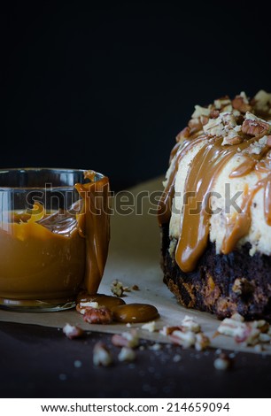 Caramel Bundt Cake with chocolate layers on dark background and caramel sauce in jar