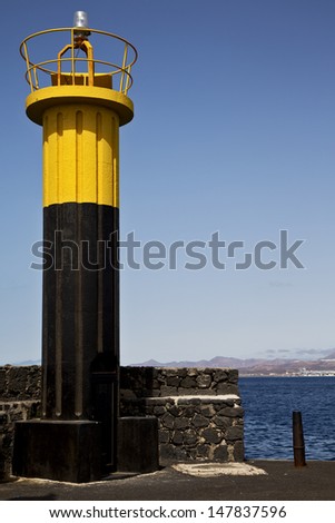 lighthouse and harbor pier boat in the blue sky   arrecife teguise lanzarote spain