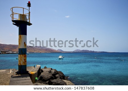 lighthouse and pier boat in the blue sky   arrecife teguise lanzarote spain