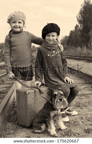 Two girls and a dog go by rail