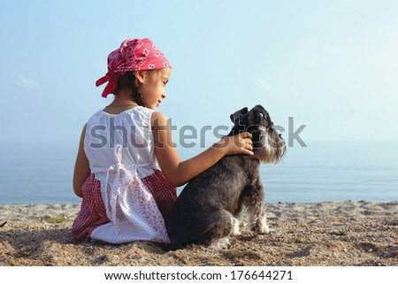 Beautiful Little Girls Embracing Her Dog Looking At The Sea