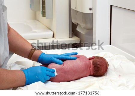 doctor examines a newborn baby in the first few minutes of life