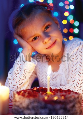 Cute little girl looking at cake