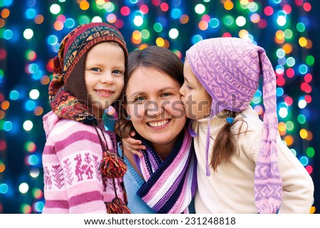 happy family mother and two little daughter playing in the winter for the Christmas holidays
