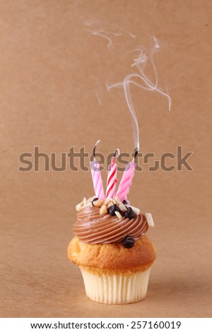 birthday cupcake with candles on plain background