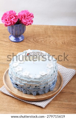 beautiful decorated cake with birthday label on wooden table