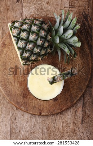 Fresh Pineapple Smoothie with slice of Pineapple on wooden board