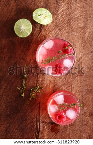 raspberry cocktail in a glass on wooden background, top view