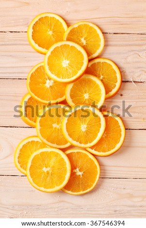 sliced fresh oranges arranged in shape on wooden background