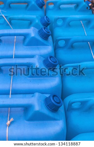 Blue plastic gas cans (fuel container) in an open market under natural lights