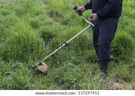 Man working with a lawn mower trimmer