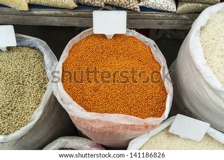 Sacks of vegetables in open market with banners