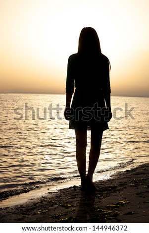 young woman\'s portrait as silhouette by the sea