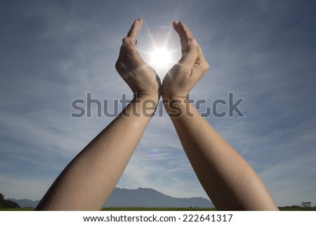 hand Sun and life / hand sun and blue sky showing freedom or solar power concept