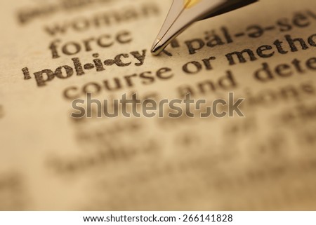 policy pen nib pointing to the words in the dictionary, shot with very shallow depth of field,