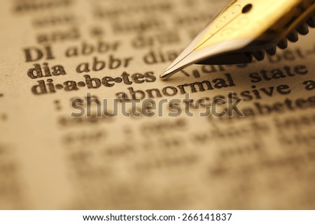 Diabetes pen nib pointing to the words in the dictionary, shot with very shallow depth of field,