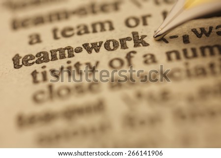 Teamwork pen nib pointing to the words in the dictionary, shot with very shallow depth of field,