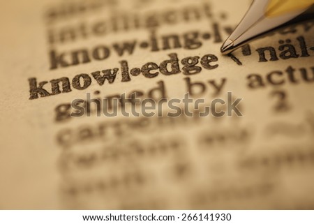 knowledge pen nib pointing to the words in the dictionary, shot with very shallow depth of field,