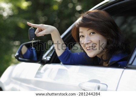 Car driver Asia woman smiling showing new car keys and white car.