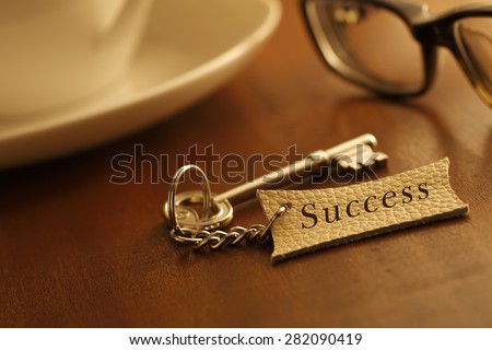 Key to success with the Success writing Leather label at  table with coffee cup
