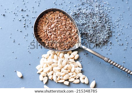 Flax seeds, sunflower and poppy seeds with silver spoon