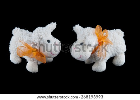 Two Stuffed  Sheep Toys on Dark Background with Orange Ribbons