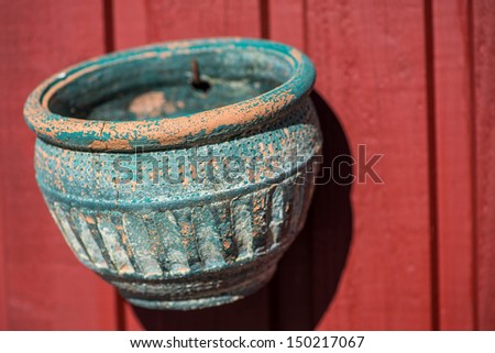 Old vase hanging on wooden wall