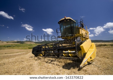 Bright yellow combine in summer at French country side