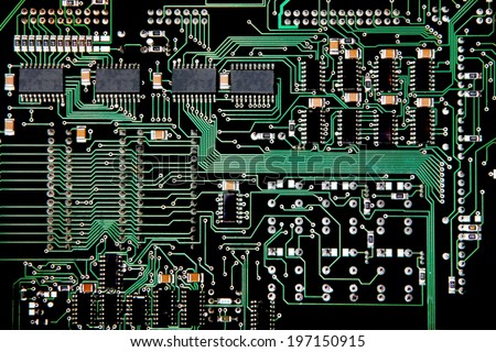 Printed Circuit board from a computer in black with green lines depicting connections.
