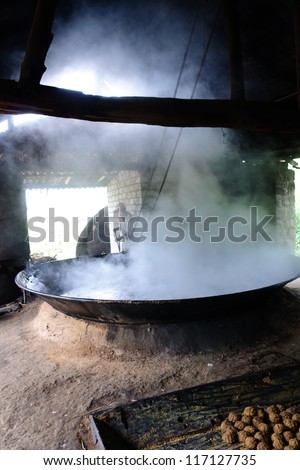 Huge pan. Vintage kitchen with smoke and fire. smoke filled. Asian cooking. Traditional way of cooking. fire and smoke. large frying pan. boiling water. vessels made of mud.