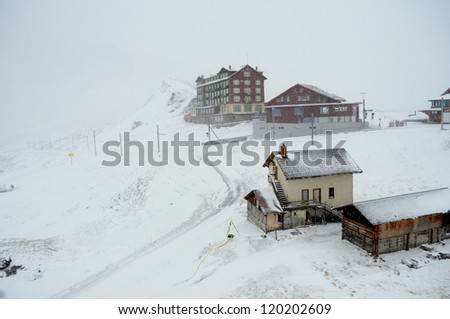 Snow covered houses on top of a mountain, Winter in alps Switzerland, snow covered mountain road. winter house