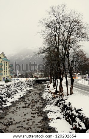 Snow filled stream with water in Switzerland.A Snow Covered Little Creek In Winter