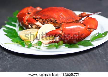 isolated Crab in a white plate with lemon and curry leaves, boiled crab