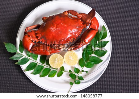 isolated Crab in a white plate with lemon and curry leaves, boiled crab