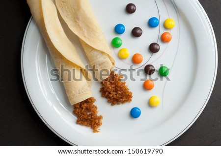 Rolled Pancakes with grated coconut filling, decorated with colorful sweet gems