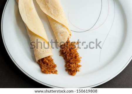 Rolled Pancakes with grated coconut filling.