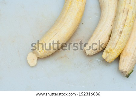 Sliced organic green cooking bananas with raw banana.banana peeled. ready to slice banana. woman slicing on a cutting board with knife.