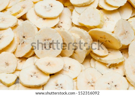 banana peeled. ready to slice banana. woman slicing on a cutting board with knife.