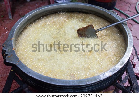 Deep frying in oil. Chicken fried in hot boiling coconut oil Kerala India. Cooking in Coconut Oil in huge tumbler.
