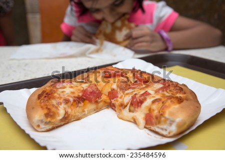 Fresh pizza with tomato and melted cheese. Hungry girl enjoying eating pizza