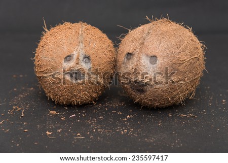 Coconuts cut in half and whole coconuts. human like face of coconut in black background. Coconut eyes nose and mouth.
