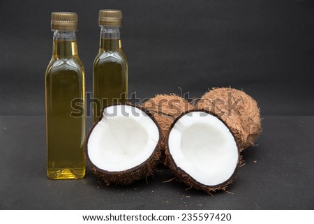 Coconuts cut in half and whole coconuts. Two bottles of coconut oil. Kerala India