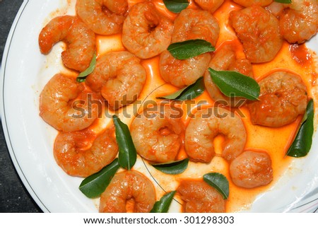 Cooked and peeled shrimps / prawns with green curry leaves ready to eat. seafood prepared in coastal cuisine of Kerala India. Main dish served in house boat
