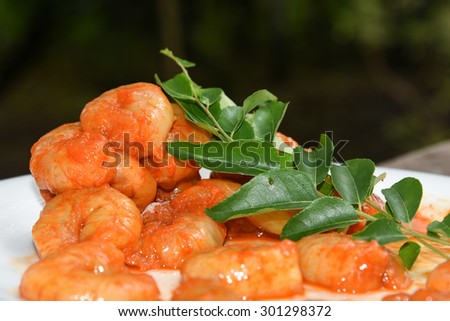 Cooked and peeled shrimps / prawns with green curry leaves ready to eat. seafood prepared in coastal cuisine of Kerala India. Main dish served in house boat